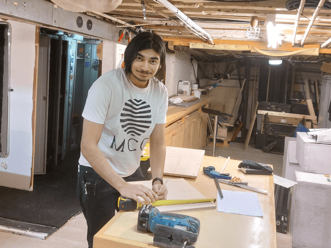 Imran a young man, Junior Technician Intern, measuring out some work under stage at the Theatre Royal Haymarket. 