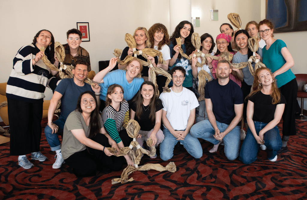 Group of Masterclass members and Paper Puppets team posing for a photograph with the paper puppets they made in the session.