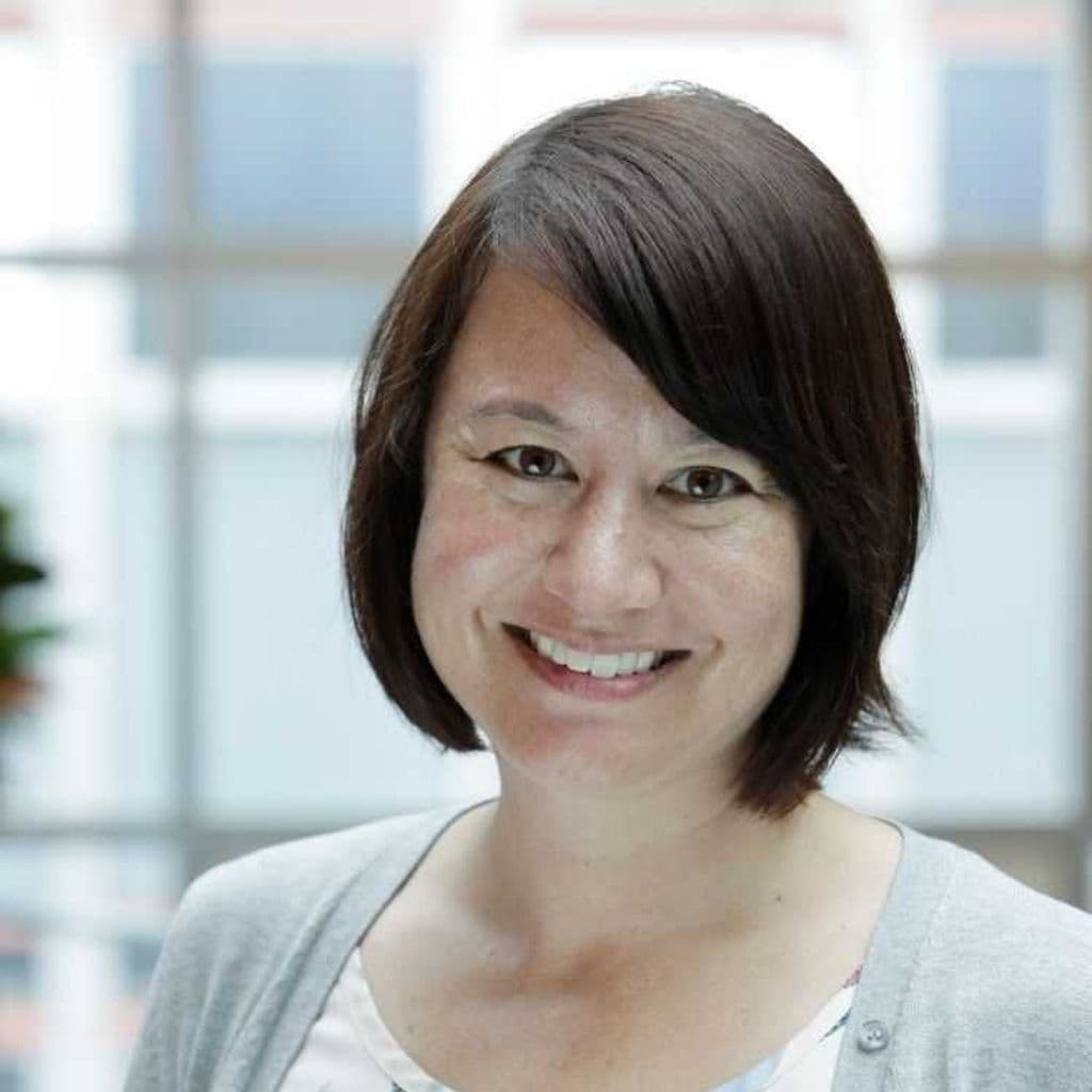 An Asian New Zealander with short black hair, with an open smile. 