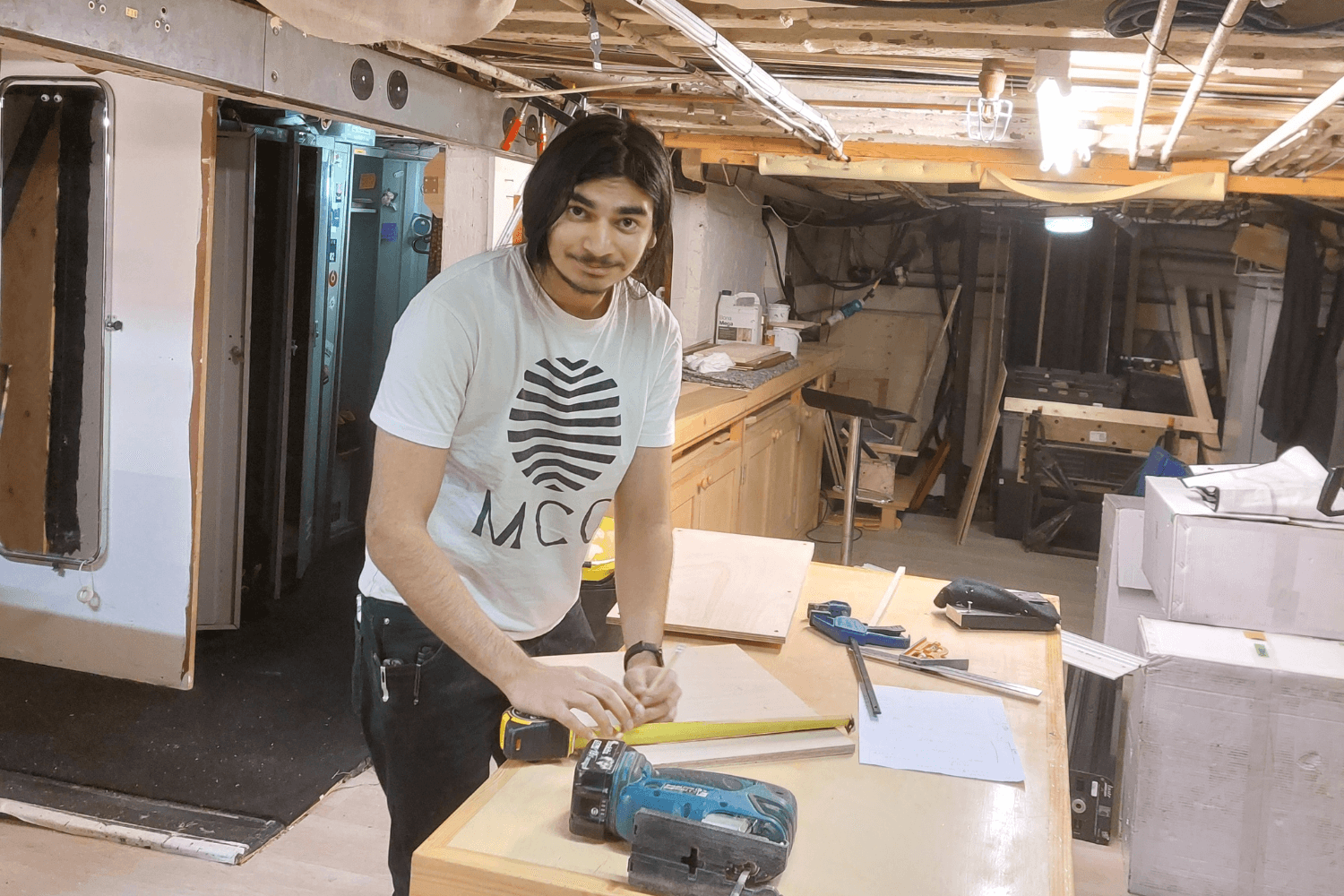 Imran a young man, Junior Technician Intern, measuring out some work under stage at the Theatre Royal Haymarket. 