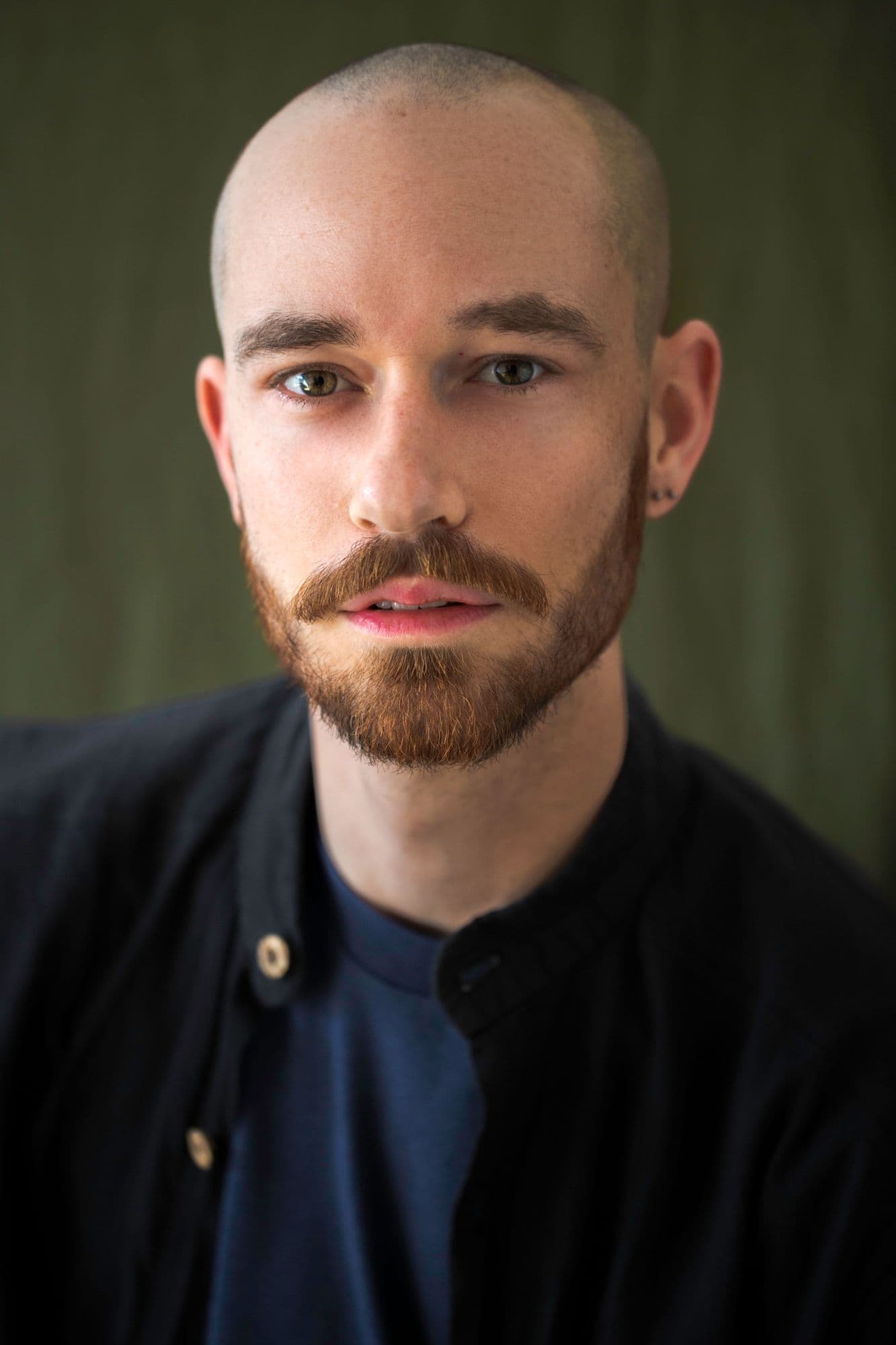 Marshall Stay headshot. A white man with a shaved head, brown eyes and styled ginger/brown beard.