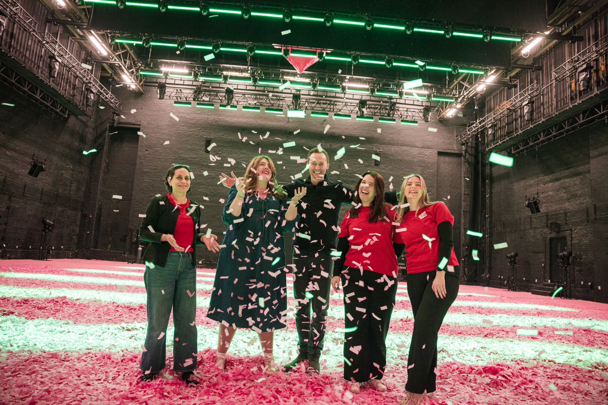 The Masterclass Team pictured with Tom Hiddleston, throwing pink confetti in the air.