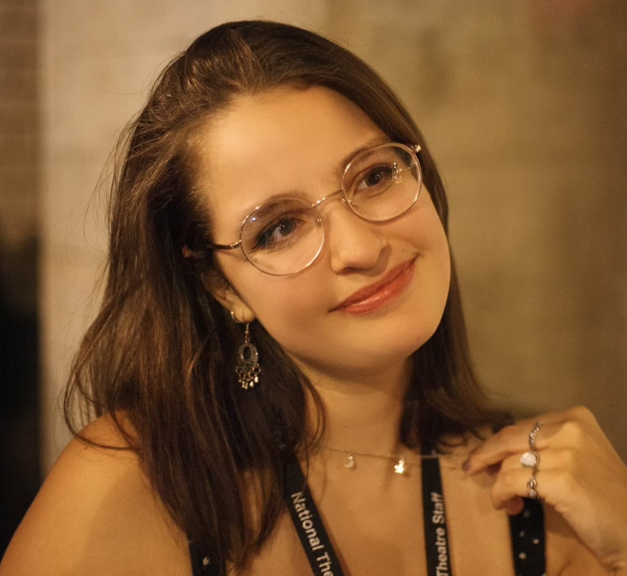 Rebecca Bullamore headshot. A white woman with brown hair and glasses, with a close smile looking just off camera.