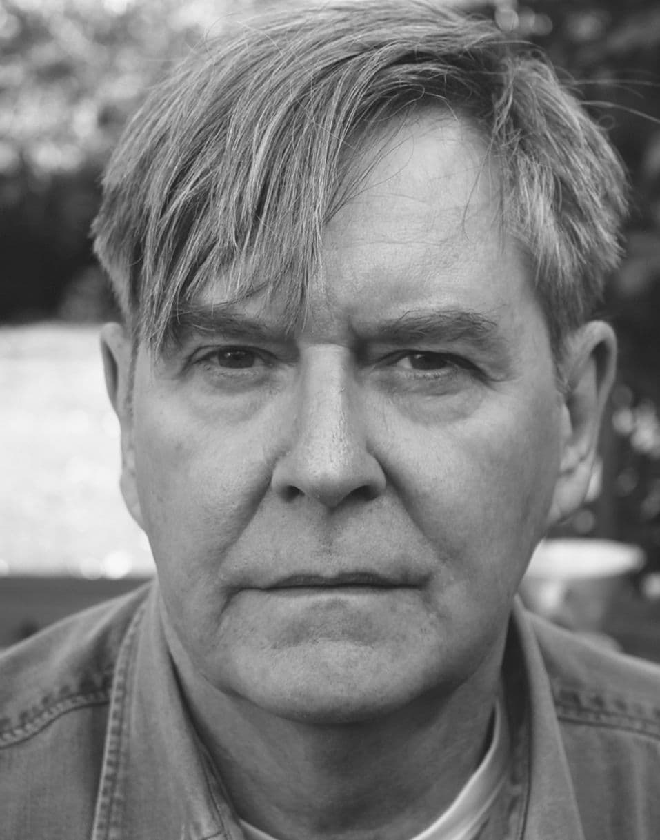 Black and white headshot of James Fleet, white man with brown hair.