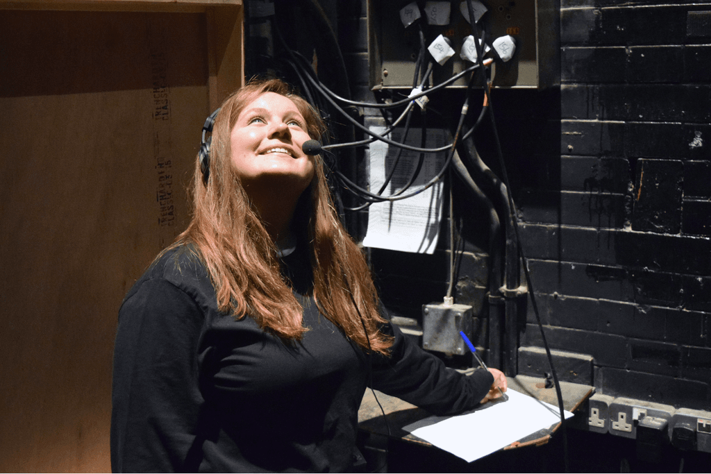 Intern Sarah Forsyth with Stage Management cans on the side of the Theatre Royal Haymarket stage